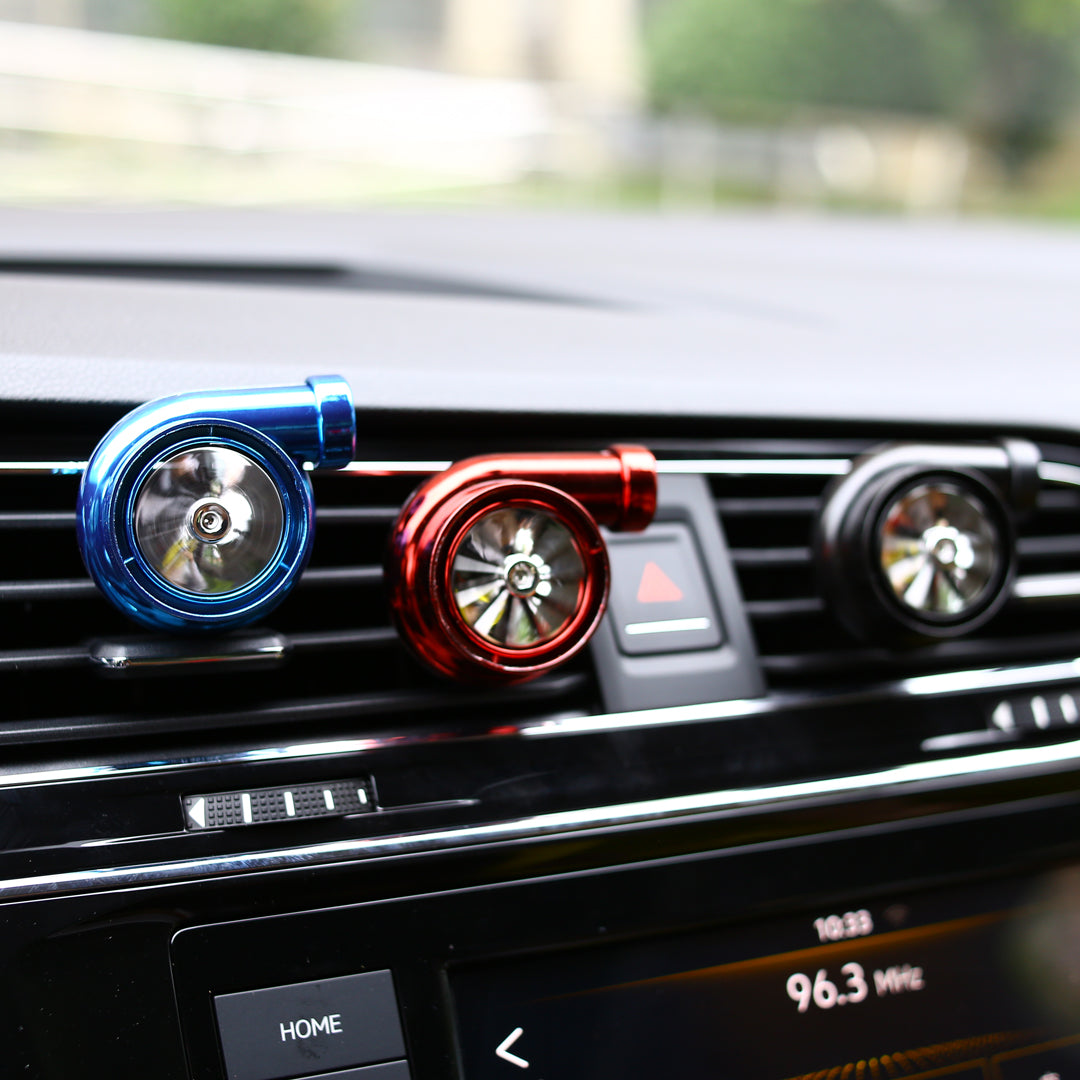 Three car air fresheners in blue, red and black colors placed in car vent, providing a fresh and stylish fragrance to your car's interior all year round.